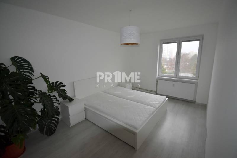 SLNEČNÝ 2i byt, REKONŠTRUKCIA, 2 X SAMOST.IZBA, BALKÓN, Haburská ulica - Spálňa so svetlou podlahou s dreveným dekorom a veľkým oknom v 2-izbovom byte.