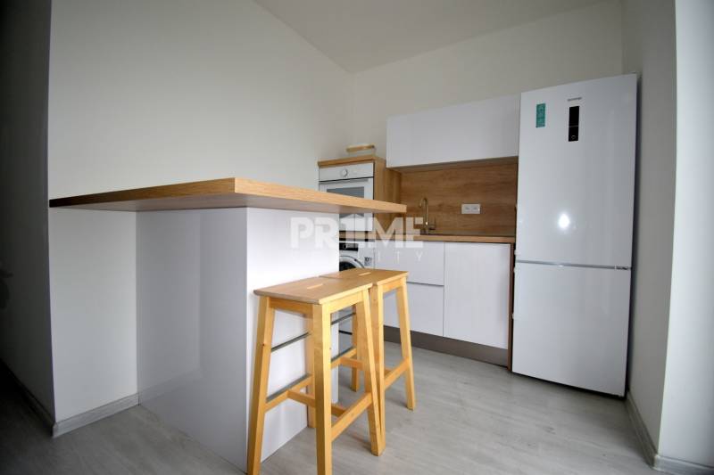 SLNEČNÝ 2i byt, REKONŠTRUKCIA, 2 X SAMOST.IZBA, BALKÓN, Haburská ulica - Kuchyňa v 2-izbovom byte s dreveným dekorom, barovým pultom a stoličkami.