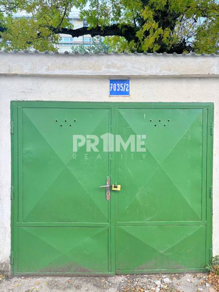 SAMOSTATNÁ GARÁŽ ( 16 m2 ), Gemerská ulica, NIVY, Ružinov - Zelená brána garáže na ulici Gemerská s číslom 7035/2, lemovaná lístím.