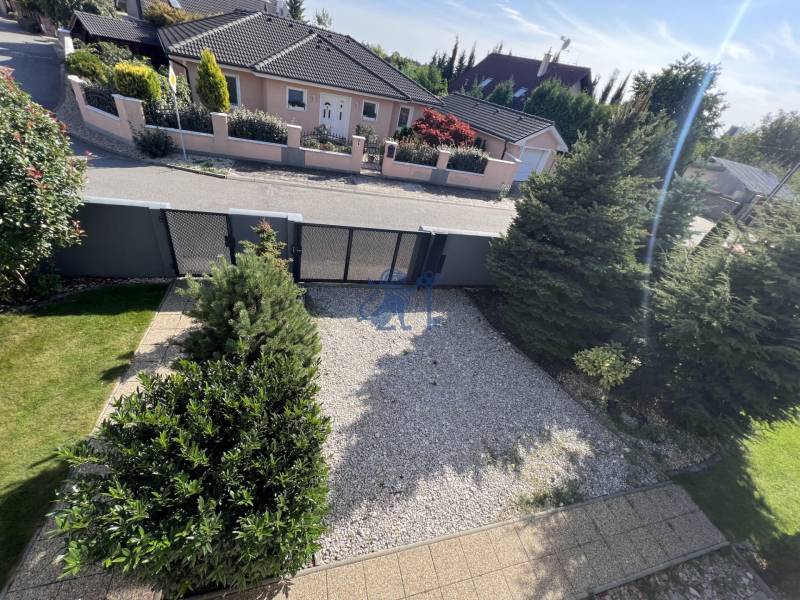 Na prenájom 3i byt v rodinom dome so záhradou - Vojenská ul. Rovinka - Záhrada s kameňmi, stromami a plotom na ulici Vojenská, oproti rodinnému domu.