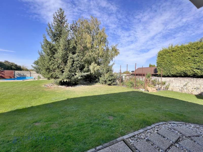 Na prenájom 3i byt v rodinom dome so záhradou - Vojenská ul. Rovinka - Záhrada so stromami, trávnikom, bazénom a kamenným plotom pri 3-izbovom byte na ulici Vojenská.