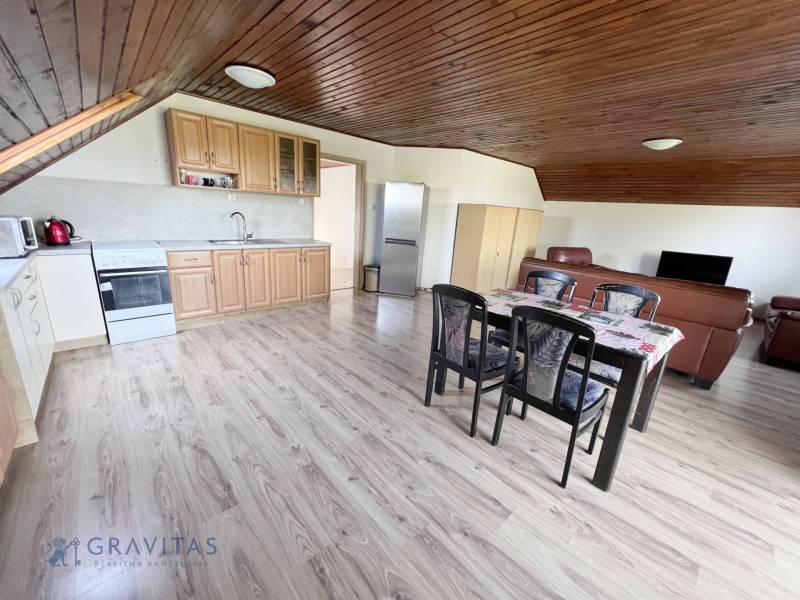 Na prenájom 3i byt v rodinom dome so záhradou - Vojenská ul. Rovinka - Kuchyňa v 3-izbovom byte na ulici Vojenská, drevený strop, jedálenský stôl, kožená sedačka.