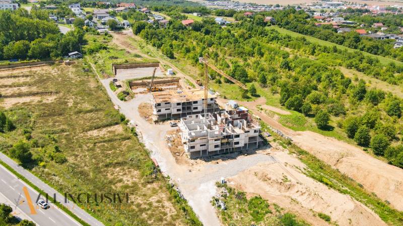 1i - 2i - 3i BYTY V NOVOSTAVBE | NITRA - MLYNARCE - Stavenisko bytového komplexu na Kmeťovej ulici v Nitre obklopené zeleňou a domami.