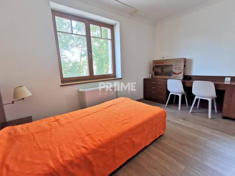 PEKNÁ GARSÓNKA, NOVOSTAVBA, KLÍMA, DRAŽDIAK HAUS, Antolská ulica - Garsónka s podlahou s dreveným dekorom, posteľou, stolom a stoličkami.