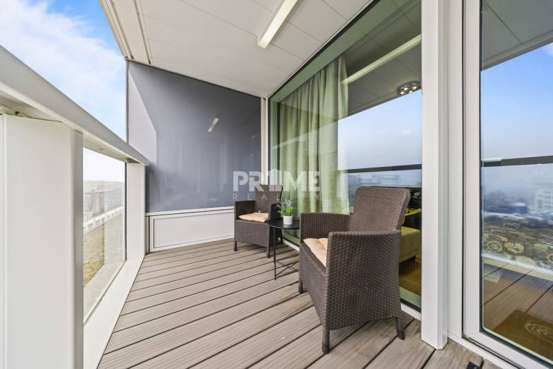 KRÁSNY 2i byt, KLÍMA, LOGGIA,VÝHĽAD,PANORAMA CITY, Landererova ulica - Balkón v 2-izbovom byte s ratanovým nábytkom a výhľadom, podlaha s dreveným dekorom.