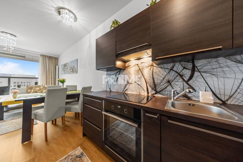 KRÁSNY 2i byt, KLÍMA, LOGGIA,VÝHĽAD,PANORAMA CITY, Landererova ulica - Kuchynský kút v 2-izbovom byte s podlahou s dreveným dekorom a jedálenským stolom.