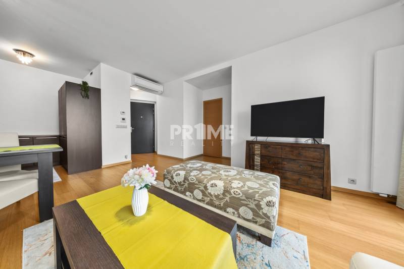 KRÁSNY 2i byt, KLÍMA, LOGGIA,VÝHĽAD,PANORAMA CITY, Landererova ulica - Obývacia izba s podlahou s dreveným dekorom v 2-izbovom byte, televízorom a elegantným nábytkom.