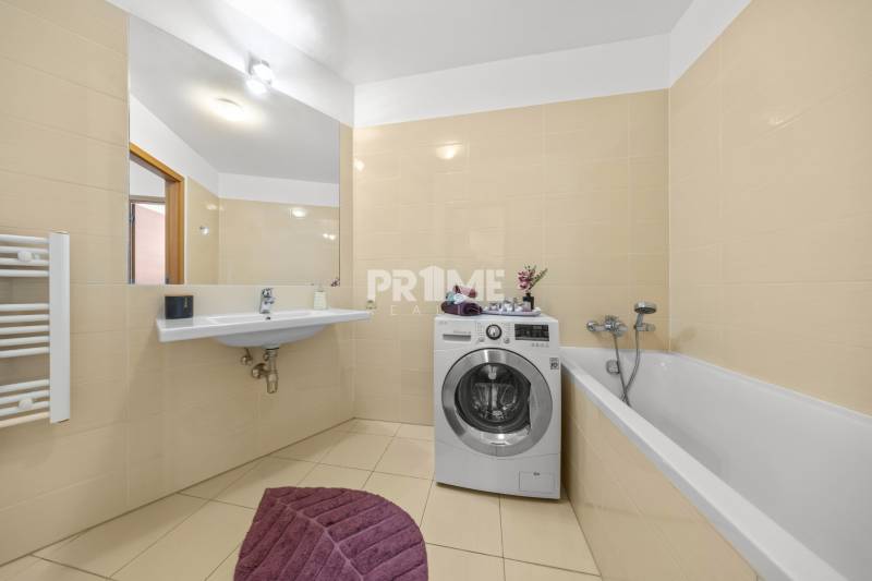 KRÁSNY 2i byt, KLÍMA, LOGGIA,VÝHĽAD,PANORAMA CITY, Landererova ulica - Kúpeľňa s vaňou, umývadlom a práčkou v 2-izbovom byte, béžová dlažba.