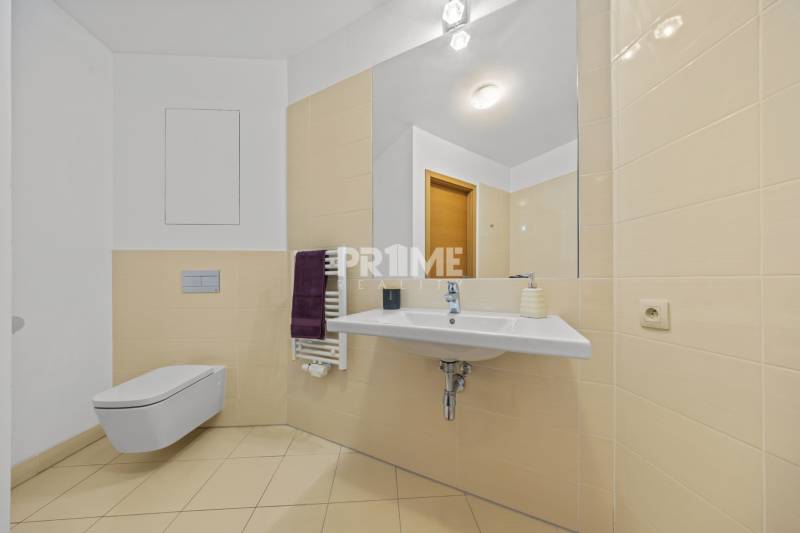 KRÁSNY 2i byt, KLÍMA, LOGGIA,VÝHĽAD,PANORAMA CITY, Landererova ulica - Kúpeľňa v 2-izbovom byte s umývadlom, zrkadlom, závesným WC a béžovými obkladačkami.