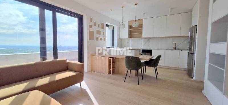 LUXUSNÝ 3i byt,PARKING,CHLADENIE,TERASA,Grand Koliba, Frankovská ulica - Obývacia izba s kuchyňou v 3-izbovom byte ponúka veľké okná a moderný dizajn.