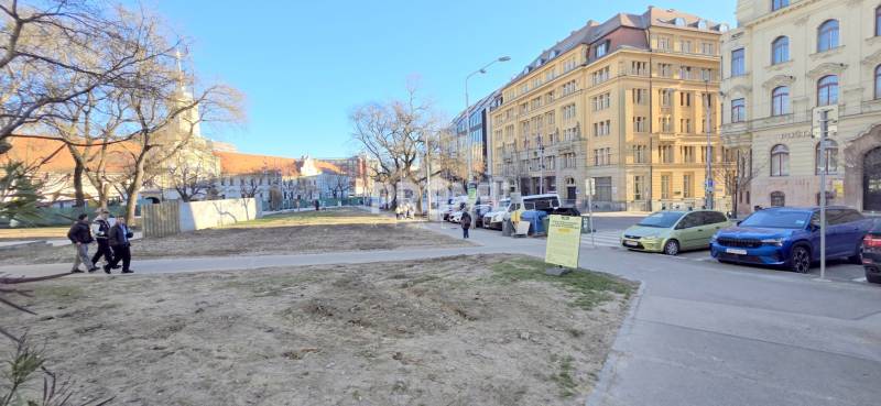 VEĽKOMETRÁŽNY 3i byt, 3 x NEPRIECHODNÁ IZBA, KLÍMA, BALKÓN, Nám.SNP - Ulica Námestie SNP v Bratislave so stromami, historickými budovami a zaparkovanými autami.