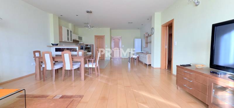 VEĽKOMETRÁŽNY 3i byt, 3 x NEPRIECHODNÁ IZBA, KLÍMA, BALKÓN, Nám.SNP - 3-izbový byt s podlahou s dreveným dekorom, jedálenským stolom a otvorenou kuchyňou.