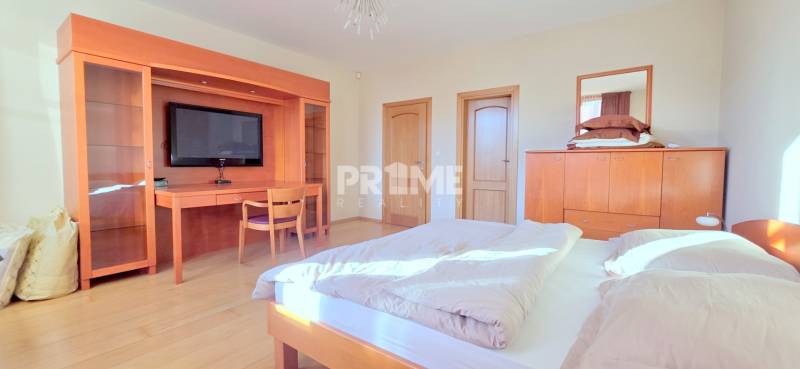 VEĽKOMETRÁŽNY 3i byt, 3 x NEPRIECHODNÁ IZBA, KLÍMA, BALKÓN, Nám.SNP - Svetlá spálňa v 3-izbovom byte s dreveným nábytkom, TV a podlahou s dreveným dekorom.