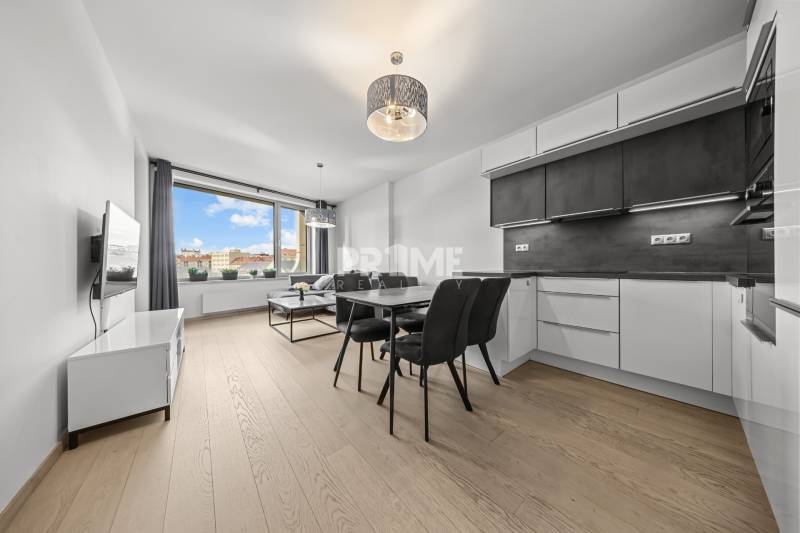 ŠTÝLOVÝ 2i byt,SKY PARK,VÝHĽAD,LOGGIA,PARKING,VEŽA II,Továrenská ul. - Kuchyňa s jedálenským stolom, pohovkou, televízorom a podlahou s dreveným dekorom v 2-izbovom byte.