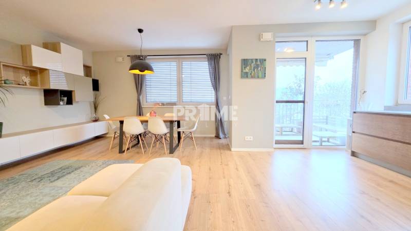 LUXUSNÝ 3i byt, TERASA, PARKING, KLÍMA, ZELENÁ HORKA, Ďumbierska ulica - Obývacia izba v 2-izbovom byte s podlahou s dreveným dekorom a jedálenským stolom.