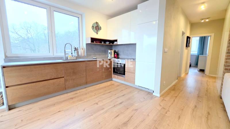 LUXUSNÝ 3i byt, TERASA, PARKING, KLÍMA, ZELENÁ HORKA, Ďumbierska ulica - Kuchyňa 2-izbového bytu s podlahou s dreveným dekorom a bielymi skrinkami.