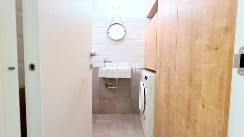 LUXUSNÝ 3i byt, TERASA, PARKING, KLÍMA, ZELENÁ HORKA, Ďumbierska ulica - Úzka kúpeľňa v 2-izbovom byte, umývadlo, práčka, zrkadlo a dlažba.