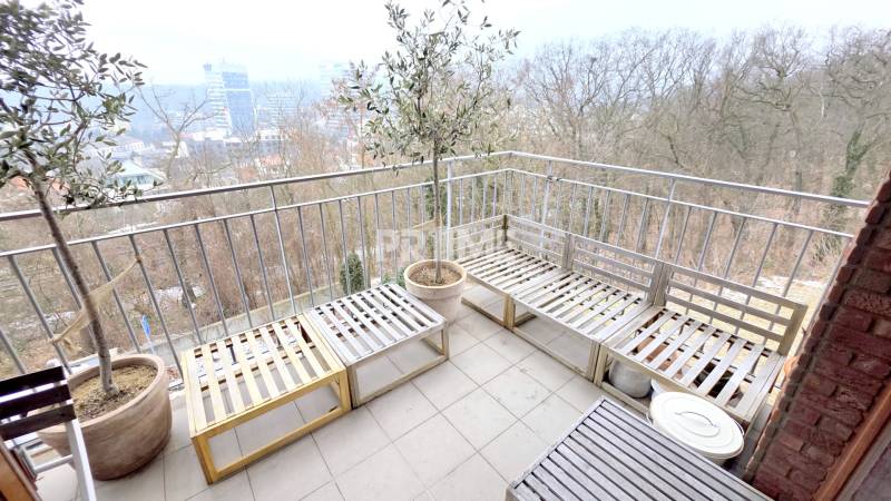 LUXUSNÝ 3i byt, TERASA, PARKING, KLÍMA, ZELENÁ HORKA, Ďumbierska ulica - Balkón s dreveným sedením, výhľadom na mesto a zeleňou v 2-izbovom byte.