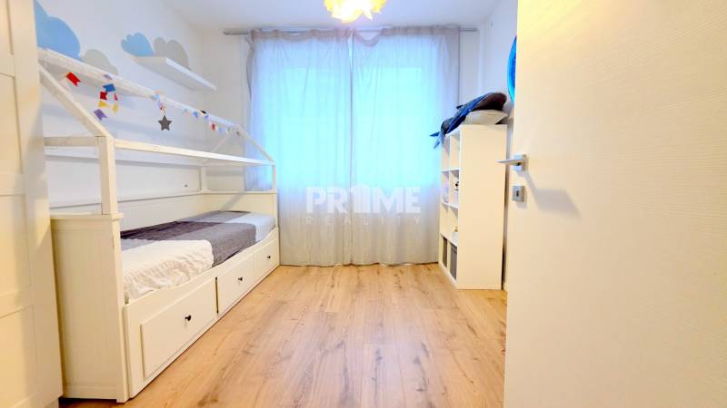 LUXUSNÝ 3i byt, TERASA, PARKING, KLÍMA, ZELENÁ HORKA, Ďumbierska ulica - Detská izba s posteľou, podlahou s dreveným dekorom a policovým regálom v 2-izbovom byte.