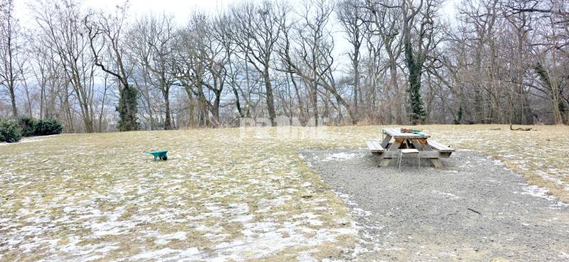 LUXUSNÝ 3i byt, TERASA, PARKING, KLÍMA, ZELENÁ HORKA, Ďumbierska ulica - Zasnežená plocha s lavičkou a fúrikom, obklopená stromami.