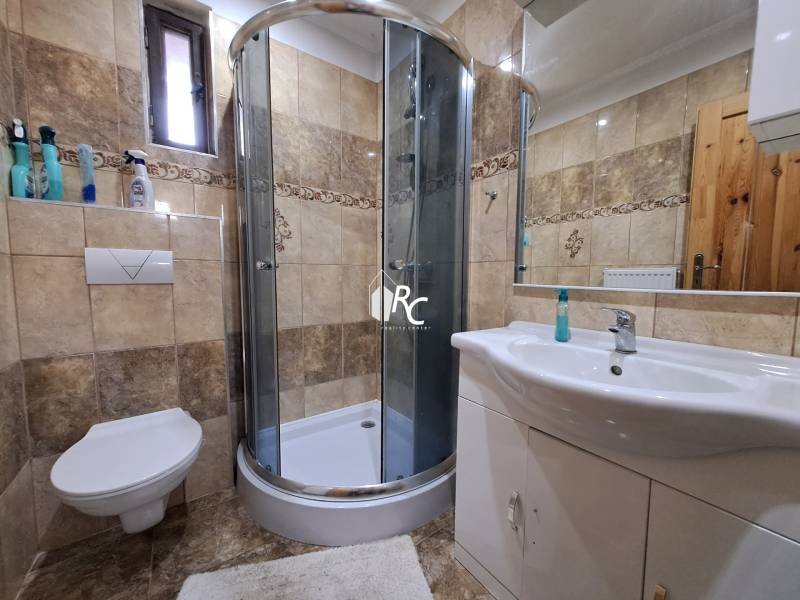 Šikovná drevenica pod lesom Slovenské Pravno  - Kúpeľňa rodinného domu s rohovou sprchou, keramickým obkladom a toaletou.