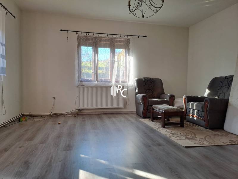 Šikovná drevenica pod lesom Slovenské Pravno  - Obývačka v rodinnom dome s kreslami a podlahou s dreveným dekorom.