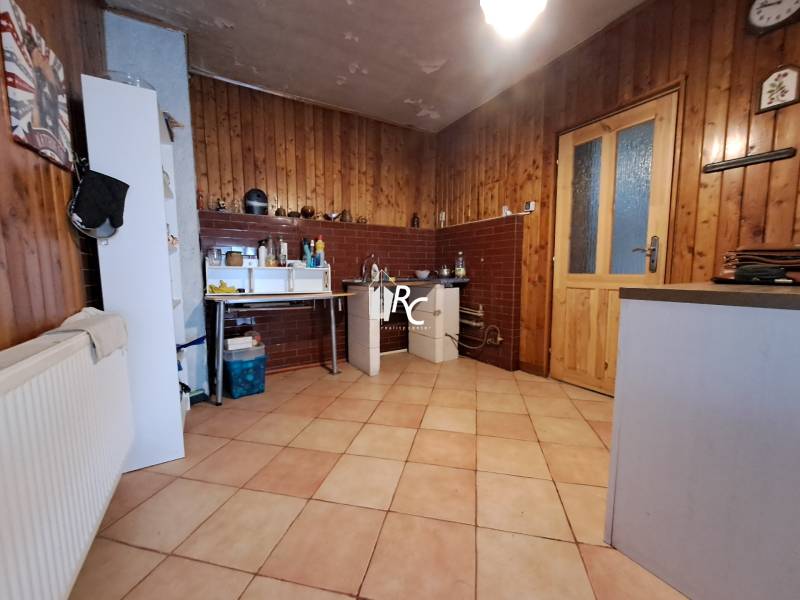 Šikovná drevenica pod lesom Slovenské Pravno  - Kuchyňa v Rodinnom dome s podlahou s dreveným dekorom, drevené obklady, jedálenský kút.