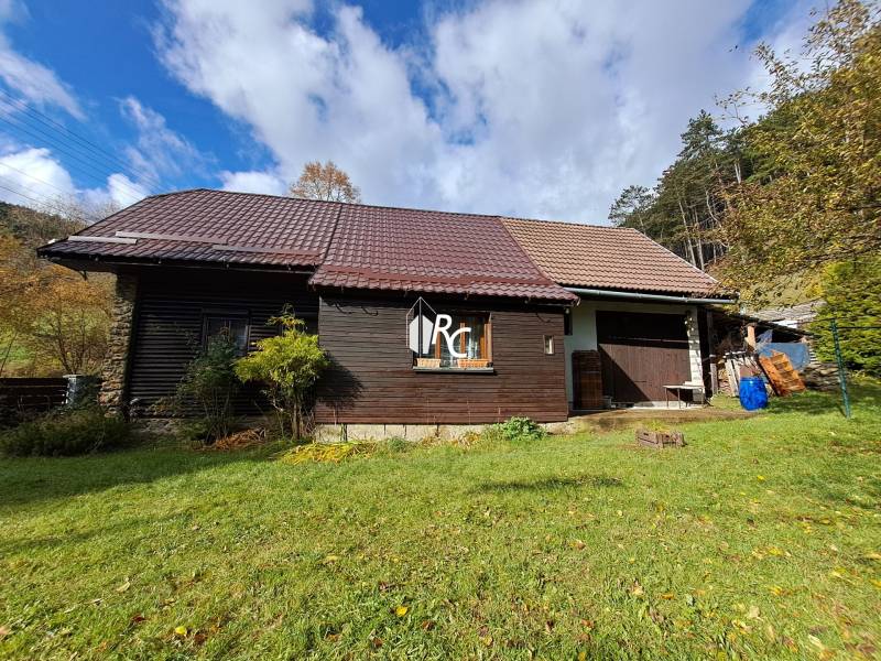 Šikovná drevenica pod lesom Slovenské Pravno  - Rodinný dom v Slovenskom Pravne so šikmou strechou a drevenou fasádou.