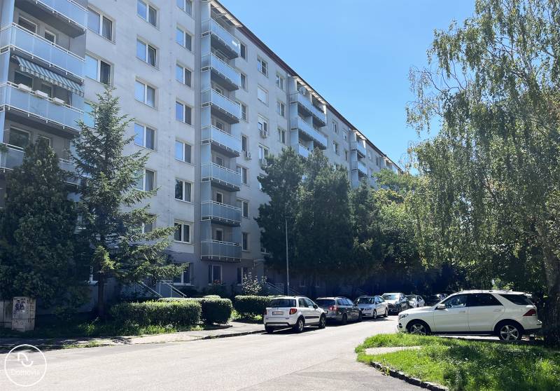 Bez provízie | Na prenájom dizajnové štúdio v Ružinove - Bytový dom na Čmelíkovej ulici v Bratislave - Ružinove so zaparkovanými autami.