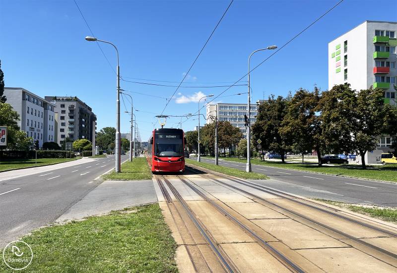 Bez provízie | Na prenájom dizajnové štúdio v Ružinove - Červená električka jazdí po ulici v Bratislave - Ružinov, Čmelíkova.