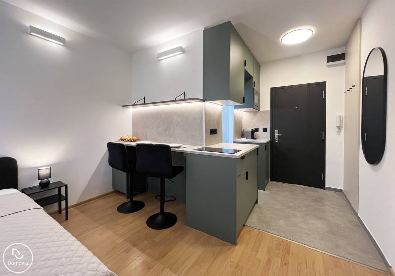 Bez provízie | Na prenájom dizajnové štúdio v Ružinove - Garsónka s kuchynským kútom, jedálenským pultom a podlahou s dreveným dekorom.