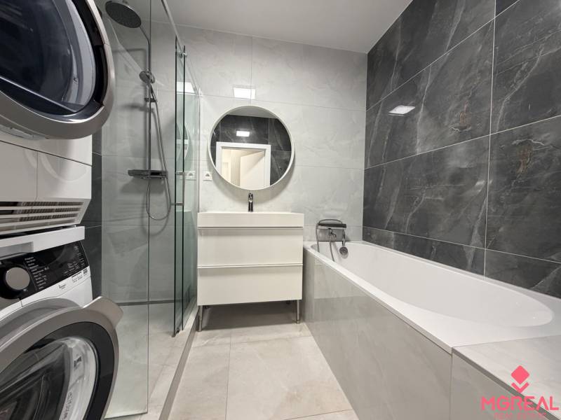 3 izbový byt s balkónom Topoľčany / PRENAJOM  - Kúpeľňa v 3-izbovom byte s vaňou, práčkou a okrúhlym zrkadlom nad umývadlom.