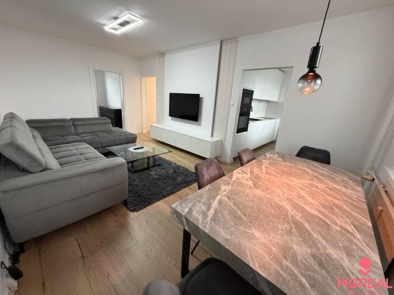 3 izbový byt s balkónom Topoľčany / PRENAJOM  - Obývacia izba so šedou sedacou súpravou a podlahou s dreveným dekorom v 3-izbovom byte.