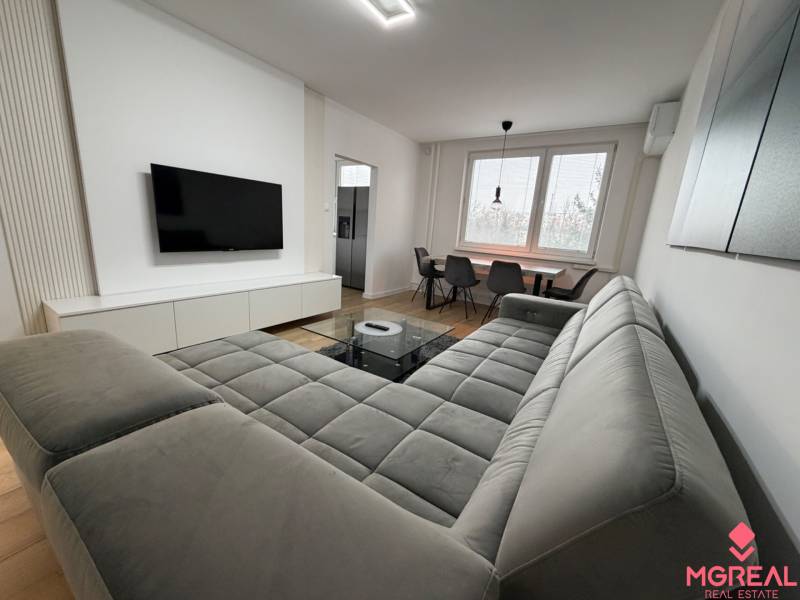 3 izbový byt s balkónom Topoľčany / PRENAJOM  - Obývací priestor v 3-izbovom byte s pohovkou, TV a jedálenským stolom, podlaha s dreveným dekorom.