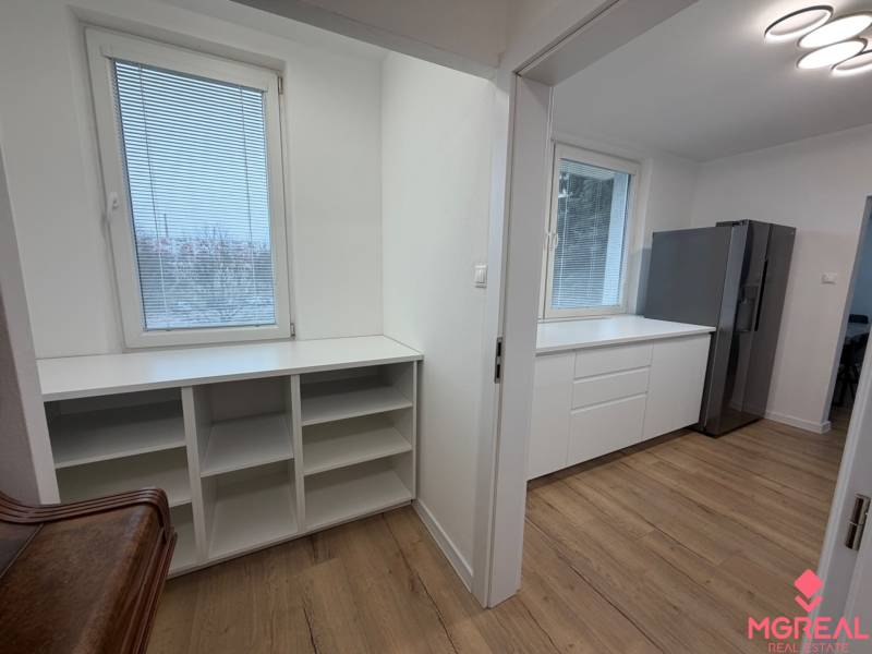 3 izbový byt s balkónom Topoľčany / PRENAJOM  - 3-izbový byt s podlahou s dreveným dekorom, bielymi skrinkami a veľkou chladničkou v kuchyni.