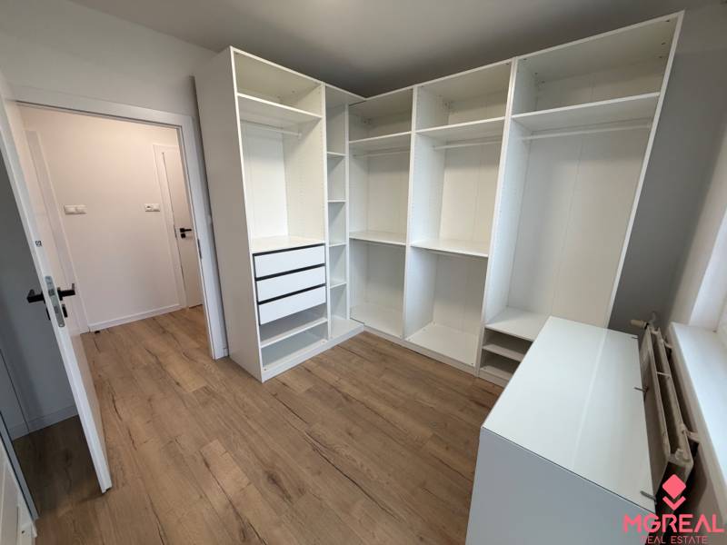 3 izbový byt s balkónom Topoľčany / PRENAJOM  - Pokoj v 3-izbovom byte s regálmi a podlahou s dreveným dekorom.