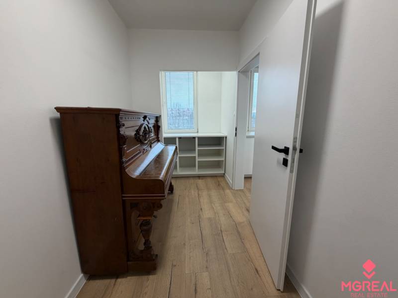 3 izbový byt s balkónom Topoľčany / PRENAJOM  - Izba s podlahou s dreveným dekorom a klavírom v 3-izbovom byte.