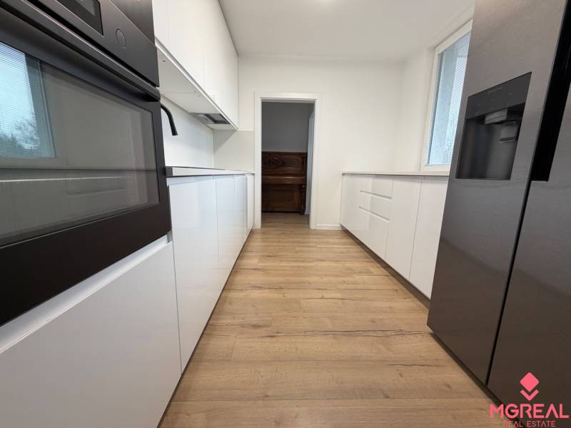 3 izbový byt s balkónom Topoľčany / PRENAJOM  - Kuchyňa s bielymi skrinkami a podlahou s dreveným dekorom v 3-izbovom byte.