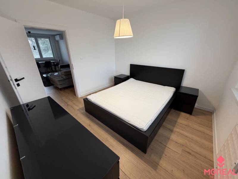 3 izbový byt s balkónom Topoľčany / PRENAJOM  - Spálňa v 3-izbovom byte s manželskou posteľou a podlahou s dreveným dekorom.