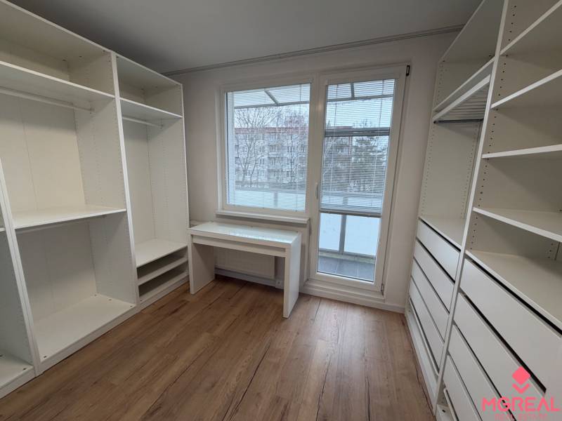 3 izbový byt s balkónom Topoľčany / PRENAJOM  - Izba v 3-izbovom byte s bielymi úložnými skriňami a podlahou s dreveným dekorom.