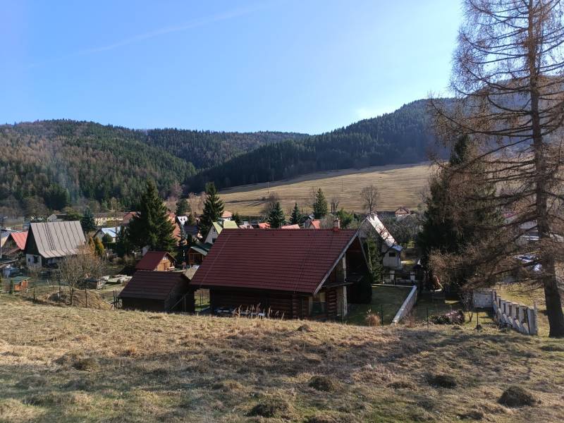 VRÍCKO - Stavebný pozemok vo výmere 1036 m2, okr.Martin - Vidiecka scenéria vo Vrícku so strechami domov a kopcovitým pozadím, Pozemky - bývanie.