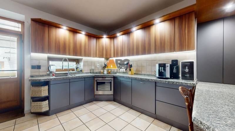 Na predaj Rodinný dom -rezort - Banská Bystrica 4500m2 - Kuchyňa v rodinnom dome s tmavými skrinkami, kávovarom a rohovým umývadlom.