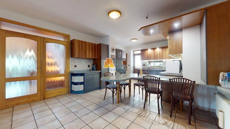 Na predaj Rodinný dom -rezort - Banská Bystrica 4500m2 - Kuchyňa v rodinnom dome s dreveným nábytkom, jedálenským stolom a keramickou dlažbou.