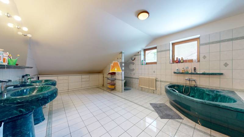 Na predaj Rodinný dom -rezort - Banská Bystrica 4500m2 - Priestranná kúpeľňa v rodinnom dome s vaňou, umývadlami a oknami s keramickým obkladom.
