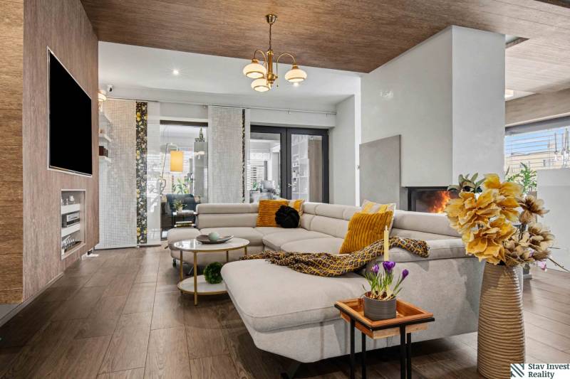 Ideálny dom pre rodinu, Blatné, okr. Senec - Obývačka v rodinnom dome s pohovkou, krbom a podlahou s dreveným dekorom.