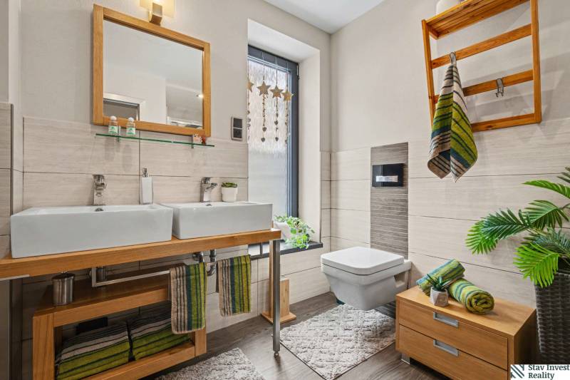 Ideálny dom pre rodinu, Blatné, okr. Senec - Kúpeľňa v rodinnom dome s dvomi umývadlami, zrkadlom, drevenou skrinkou a dekoráciami.