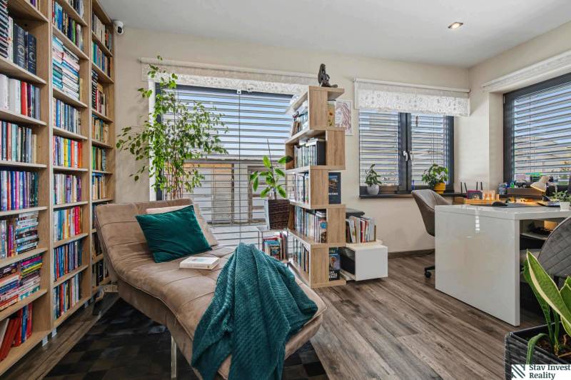 Ideálny dom pre rodinu, Blatné, okr. Senec - Knižnica s pohovkou v rodinnom dome so zeleňou a podlahou s dreveným dekorom.