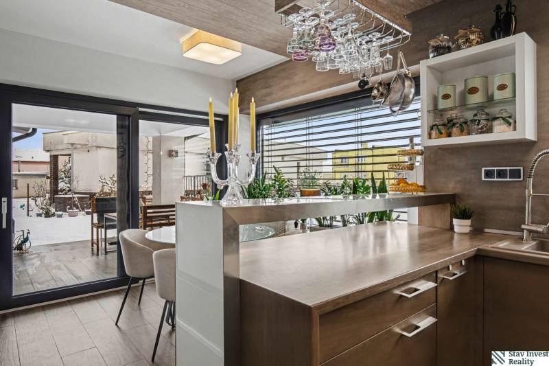 Ideálny dom pre rodinu, Blatné, okr. Senec - Kuchyňa v rodinnom dome s podlahou s dreveným dekorom a výhľadom na terasu.