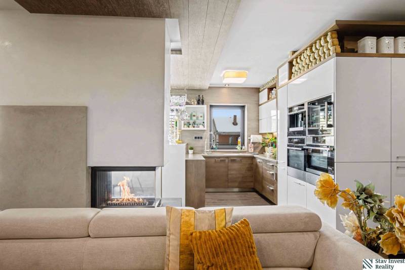 Ideálny dom pre rodinu, Blatné, okr. Senec - Interiér rodinného domu s kuchyňou, kozubom, pohovkou a dekoratívnymi prvkami.