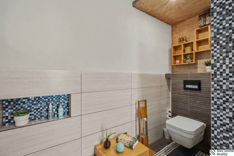 Ideálny dom pre rodinu, Blatné, okr. Senec - Kúpeľňa v rodinnom dome s obkladom rôznych vzorov a dekoratívnymi policami.